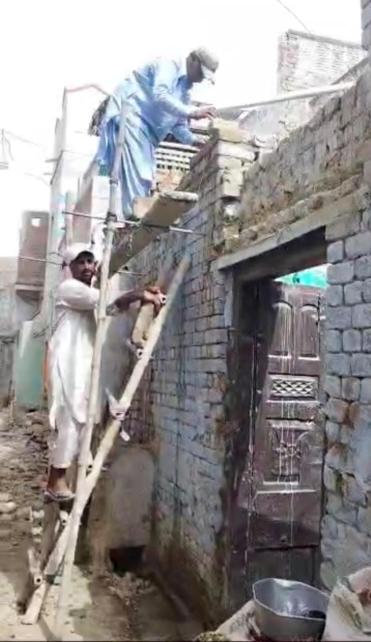 Residents repairing a rain-damaged home